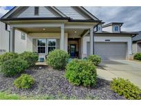 Charming front exterior of home with brick accents, covered porch, and well-maintained landscaping at 5650 Bergeson Ways, Cumming, GA 30028
