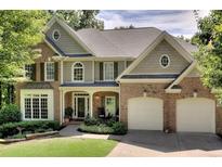 Charming two-story home featuring brick and siding, a well-manicured lawn, and an attached two-car garage at 6795 Preston Glen Dr, Alpharetta, GA 30005