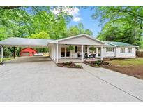 Charming ranch-style home featuring a carport, covered porch, and well-maintained landscaping at 5766 Macland Rd, Powder Springs, GA 30127