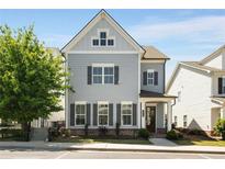 Charming two-story home featuring light blue siding and dark shutters against the backdrop of a clear blue sky at 2316 Echelon Ln, Smyrna, GA 30080