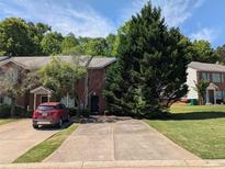 Townhome with brick facade, driveway, and mature landscaping in a residential neighborhood at 3789 Waldrop Ln, Decatur, GA 30034