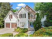 Charming two-story home featuring a stone accent wall, two car garage, and well-manicured landscaping at 1169 Dawn View Nw Ln, Atlanta, GA 30327
