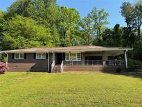 Charming brick home featuring a covered front porch and well-manicured lawn at 4416 Arcadia Dr, Norcross, GA 30093