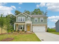 Charming two-story home features a stone and siding exterior, attached two-car garage, and well-manicured lawn at 5377 Heron Bay Blvd, Locust Grove, GA 30248
