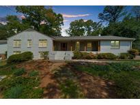 Charming brick home with a welcoming front porch and mature trees, perfect for outdoor relaxation at 7300 Wynhill Dr, Sandy Springs, GA 30328