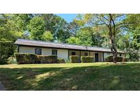 Inviting single-story home with a well-manicured lawn and mature landscaping at 3451 San Antonio Dr, Snellville, GA 30039