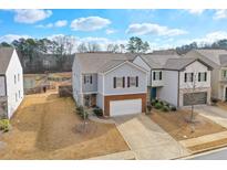 Charming two-story home features a brick-accented garage, neutral siding and a well-manicured lawn at 137 Centennial Ridge Dr, Acworth, GA 30102