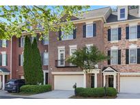 Beautiful brick townhome with black shutters, a two-car garage, and mature landscaping at 478 Vinings Estates Se Dr # B02, Smyrna, GA 30126
