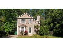 Charming two-story home with a manicured lawn and mature trees providing shade and privacy at 728 Brittany Ct, Stone Mountain, GA 30083