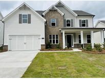 Charming two-story home featuring a brick facade, white siding, and a well-manicured lawn at 3355 Hillshire Dr, Cumming, GA 30028