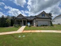 Charming single-story home with brick and siding, a well-manicured lawn, and a two-car garage at 301 Sobeck Way, Canton, GA 30115