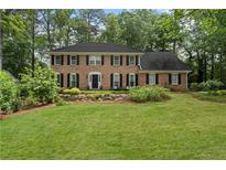 Traditional brick home with a well-maintained lawn and landscaping, creating a classic curb appeal at 4979 Shadow Glen Ct, Dunwoody, GA 30338