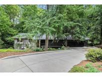 Charming home with lush landscaping and a long driveway leading up to the entrance at 2361 Woodward Nw Way, Atlanta, GA 30305