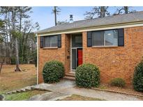 Charming brick home with black shutters, red door, and manicured landscaping at 3344 Northcrest Rd # A, Atlanta, GA 30340