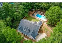 Stunning aerial view of a charming home with a pool surrounded by lush greenery and mature trees at 436 Westlake Nw Dr, Marietta, GA 30064