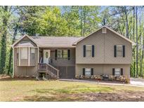 Charming home with a welcoming front porch, stone accents, and beautiful landscaping at 204 Holly Creek Way, Woodstock, GA 30188
