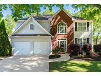 Charming two-story home featuring a two-car garage, brick accents, manicured lawn and beautiful shrubbery at 2264 Howell Farms Nw Trl, Acworth, GA 30101