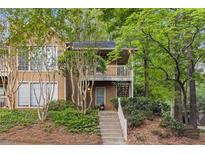 Inviting two-story townhouse with a landscaped front yard and cozy balcony, perfect for enjoying the surrounding greenery at 2308 Country Park Se Dr, Smyrna, GA 30080