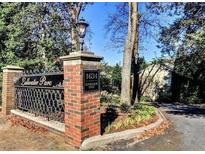 Community entrance with brick signage, mature trees, and street lamp at 1634 Ponce De Leon Ne Ave # 506, Atlanta, GA 30307