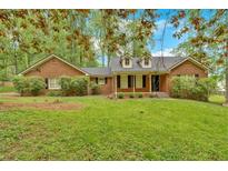 Charming brick home featuring a well-maintained lawn and mature trees at 151 Mark Se Ln, Smyrna, GA 30082