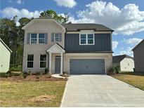 Charming two-story home with a combination brick and siding exterior, attached garage, and inviting curb appeal at 5383 Heron Bay Blvd, Locust Grove, GA 30248