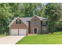 Traditional two-story brick home with a well-manicured lawn and an attached two-car garage at 99 Ashtonbrook Dr, Mcdonough, GA 30252