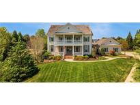 Charming two-story home with manicured lawn, lush landscaping, and double front porch at 210 Tifton Ln, Roswell, GA 30075