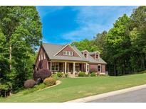 Charming two-story home with a lush front yard, mature trees, and a welcoming porch at 313 Red Fox Dr, Canton, GA 30114
