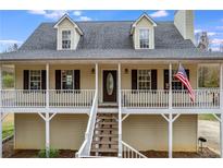 Charming home featuring a welcoming front porch, dormer windows, and neatly maintained landscaping at 115 N Loblolly Xing, Temple, GA 30179