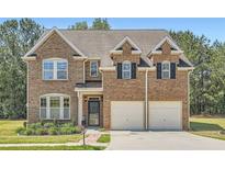 Inviting two-story brick home with a well-manicured lawn and a two-car garage at 23 Dynasty Dr, Fairburn, GA 30213