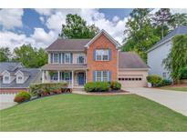 Charming two-story brick home with a well-manicured lawn and inviting front porch at 1099 Mount Water Ln, Lawrenceville, GA 30043