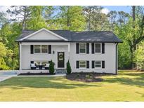 Charming two-story home with a well-manicured lawn and a classic white brick facade at 2120 Pair Sw Rd, Marietta, GA 30008
