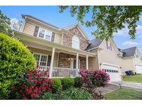 Inviting two-story home featuring a covered front porch, stone accents, and well-maintained landscaping at 2164 Caneridge Sw Dr, Marietta, GA 30064