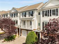 Charming townhome with white siding, black shutters, a garage, and a small front porch at 735 Neel Reid Dr, Roswell, GA 30075