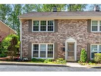 Charming brick townhouse with inviting curb appeal and mature landscaping at 2495 Northlake Ne Ct, Atlanta, GA 30345