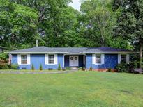 Charming blue ranch-style home featuring a lush lawn, classic white windows, and a welcoming front entrance at 4579 Amberly S Ct, Atlanta, GA 30360