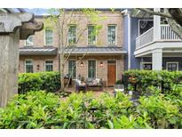 Charming brick townhouse features a lovely patio with iron fence and ample seating area at 719 Hammond Dr, Woodstock, GA 30188