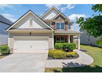 Charming two-story home with a two-car garage and manicured landscaping at 3625 New River Ct, Cumming, GA 30040