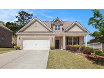 Charming single-Gathering home with a brick facade, manicured lawn, and a two-car garage at 5749 Creek Indian Dr, Sugar Hill, GA 30518