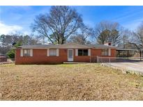 Charming brick ranch-style home with a well-maintained front yard and a covered carport at 60 Highland Dr, Stockbridge, GA 30281