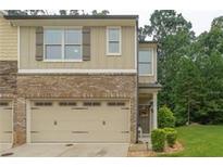 Charming townhouse showcasing a beige exterior, an attached garage and well-kept front lawn at 236 Bobbie Way, Woodstock, GA 30189
