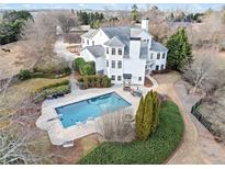 Aerial view of a luxury home with a stunning backyard pool and well-manicured landscaping and a horse in the field at 401 Nichols Dr, Suwanee, GA 30024
