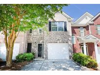 Charming brick townhome featuring a one-car garage, black door and shutters, and a well-maintained front yard at 2263 Leicester Se Way, Atlanta, GA 30316