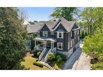 Charming two-story home with a landscaped yard, inviting front porch, and driveway leading to a private pool at 331 Peachtree Ne Ave, Atlanta, GA 30305