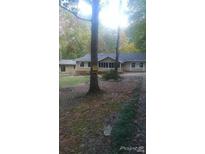 Inviting one-story home featuring a screened-in porch nestled among mature trees at 40 Burma Rd, Mcdonough, GA 30252