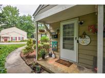 Inviting front door with landscaping, walkway, and charming decor in a well-maintained community at 1304 Old Coach Sw Rd, Marietta, GA 30008