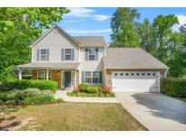Charming two-story home with a well-manicured lawn, complemented by stone accents and a two car garage at 182 Garden Manor Ct, Loganville, GA 30052