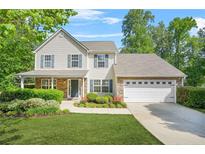 Charming two-story home featuring a landscaped front yard and a two-car garage at 182 Garden Manor Ct, Loganville, GA 30052