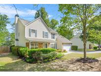 Charming two-story home with landscaped yard, complemented by lush greenery and a well-maintained lawn at 182 Garden Manor Ct, Loganville, GA 30052