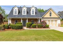 Charming home with stone accents, dormer windows, manicured lawn, and attached two-car garage at 3012 Keeneland Blvd, Mcdonough, GA 30252